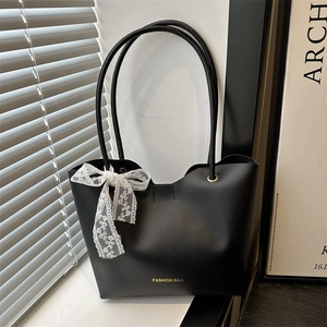 Minimalistische schwarze Tragetasche aus Kunstleder mit weißer Spitzenschleife und Goldakzent