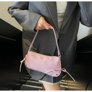 Detailaufnahme der rosa sichelförmigen Schultertasche mit Schleife und Nieten