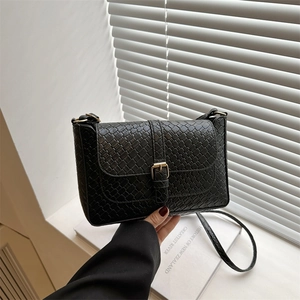 Sac sous le bras chic noir à texture tissée avec boucle dorée pour printemps 2025