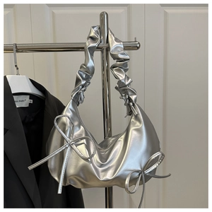 Close-up of metallic silver cloud bag featuring pleated straps and bow details