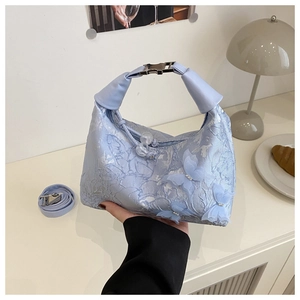 Détail du sac en dentelle bleu clair avec papillons en tulle 3D et broderies fines