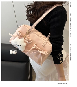 Pink shoulder bag with 3D bows and plush cloud charm shown on a female model