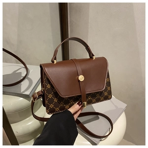 Detailed view of retro brown printed leather bag with metallic clasp and adjustable strap