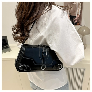 Vue détaillée d'un sac à bandoulière en cuir verni noir avec boucles argentées chic