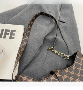 Dettaglio della borsa a spalla vintage in tela monogram con catena dorata e inserti in pelle