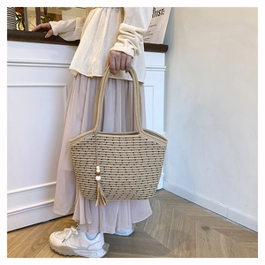 Detailed texture of woven cotton straw tote with long tassels and decorative beads