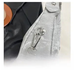Close-up of polished silver metal hooks and D-ring on silver embossed leather handbag