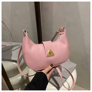 Dettaglio della borsa a spalla a mezzaluna rosa con chiusura a triangolo dorata
