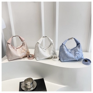 Détail de trois sacs à main en satin avec broderie en dentelle et papillons en relief