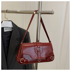 Détail du sac sous le bras vintage rouge foncé avec boucle argentée et cuir brillant