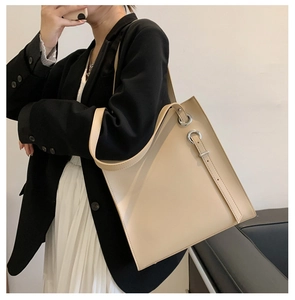 Detail shot of a beige minimalist tote bag with smooth texture and metal ring accents