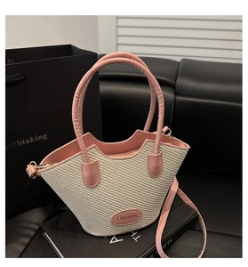 Dettaglio della borsa tote in paglia intrecciata e pelle rosa con bordo ondulato