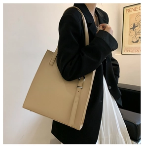 Detailed side view of beige PU leather tote bag with elegant metal ring buckle detail
