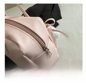 Gros plan sur la fermeture éclair argentée et le cuir rose souple du sac fourre-tout