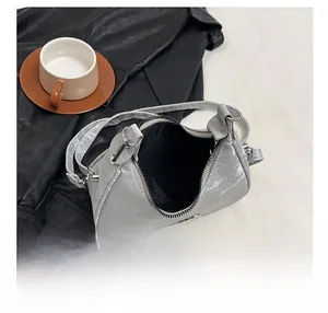 Detail view of silver pleated hobo bag showing spacious interior with metal zip closure