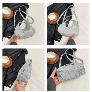 Detail of silver crescent moon bag with metallic texture and bow metal accent