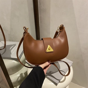 Borsa a mezzaluna marrone con fibbia a triangolo dorata su base geometrica bianca