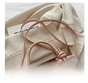 Dettaglio dell'elegante ricamo floreale e manico a nodo sulla borsa a secchiello rosa