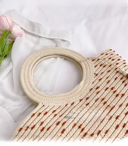 Detail of woven straw tote bag with round handles and beige brown dotted texture