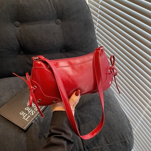 Retro red glossy leather shoulder bag with decorative bows and silver rivet details