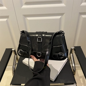 Sac sous le bras noir brillant avec boucles argentées sur fond minimaliste moderne