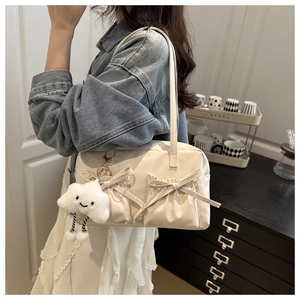 Detailed view of cream tote bag featuring cute bow pockets and a soft cloud charm