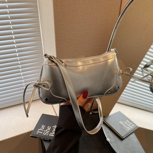 Chic silver metallic shoulder bag with ribbon bow accents and polished rivet details