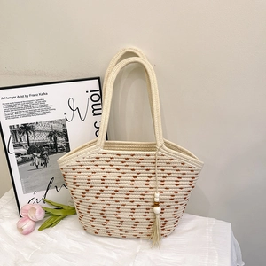 Minimalist woven straw tote bag with brown dot texture and beaded tassel charm