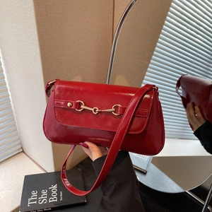 Elegant red glossy leather underarm bag with gold horsebit buckle and mirror reflection