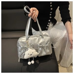 Close-up of metallic silver bowling bag featuring bow details and a cute cloud charm