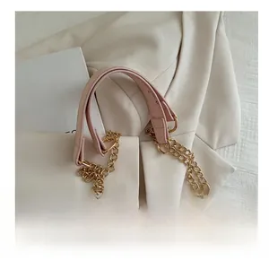 Close-up of pink snakeskin pattern bag with gold chain and reinforced handle