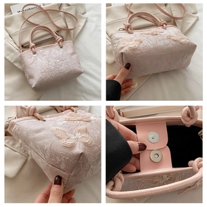 Dettaglio borsa a secchiello rosa con ricami floreali in pizzo e farfalle 3D