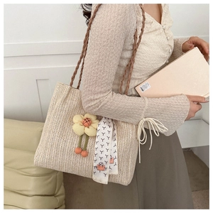 Détail du sac seau en paille tressée avec breloques fleurs cerises et foulard en soie