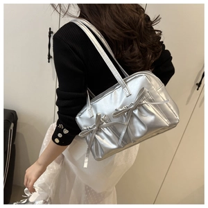 Detail of silver metallic shoulder bag featuring oversized double bow and pleat design
