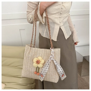 Sac seau tressé beige avec breloque fleurie et détail de foulard en soie à motifs