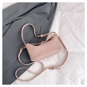 Detailed macro view of soft pink lychee grain leather texture and gold metal hardware