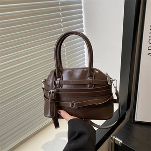 Deep brown vintage leather handbag with decorative buckled straps and top handles