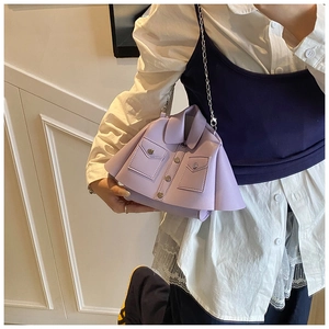 Detail of lavender jacket-shaped crossbody bag with silver chain strap on model