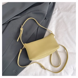 Close-up of light yellow lychee pattern leather pillow bag with silver zipper detail