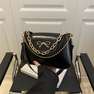 Sac sous le bras noir brillant avec boucle nœud dorée et double chaîne en métal
