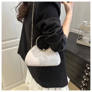 Detail of white jacquard floral evening bag with golden ring handle and chain strap