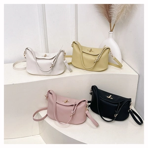 Close-up of four minimalist half-moon crossbody bags in litchi textured leather