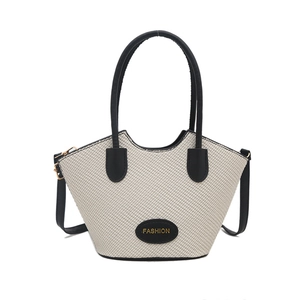 Beige woven handbag with black top handle and adjustable shoulder strap for women