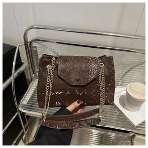 Detail of dark brown snake print handbag with golden chain strap and textured leather