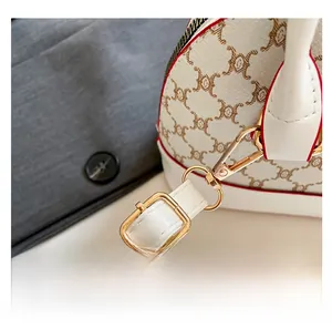 Detail of adjustable leather strap with gold hardware and retro print on shell bag