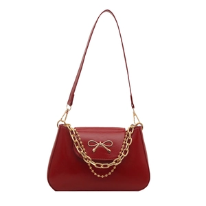 Retro red leather shoulder bag with gold bow ornament and dual decorative chains