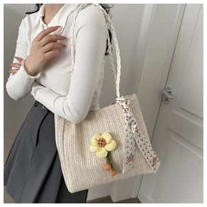 Sac seau tissé beige minimaliste avec breloque fleurie et foulard en soie pour l'été