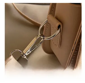 Detail of khaki saddle bag showing high-quality lychee grain leather and metal hardware