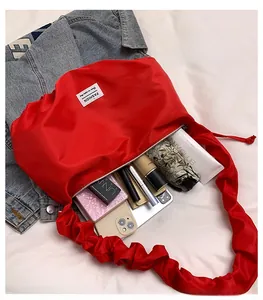 Internal storage detail of red nylon bag showing capacity for phone and cosmetics