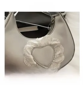 Close-up of silver leather hobo bag featuring heart leather patch and white lace edges